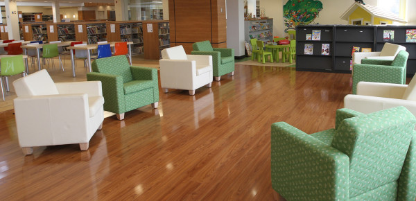 Dans la bibliothèque, des fauteuils verts et blancs sont placés en cercle