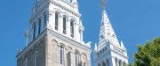 Pignon blanc de l'Église Sainte-Thérèse-d'Avila avec une tourelle blanche sur laquelle se trouve un crucifix en or