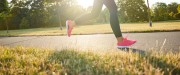 À l'extérieur dans un parc, jambes d'une femme en leggings noirs avec des souliers roses qui courent