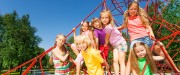 Groupe d'enfants portant des vêtements de couleur vive sont dans un module de toile d'araignée rouge