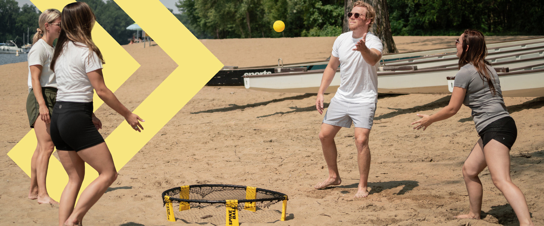Groupe de jeune adultes sur une plage qui joue au jeu du Spikeball.