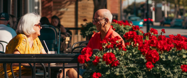 Couple assis sur une terrasse extérieure pour prendre un café.