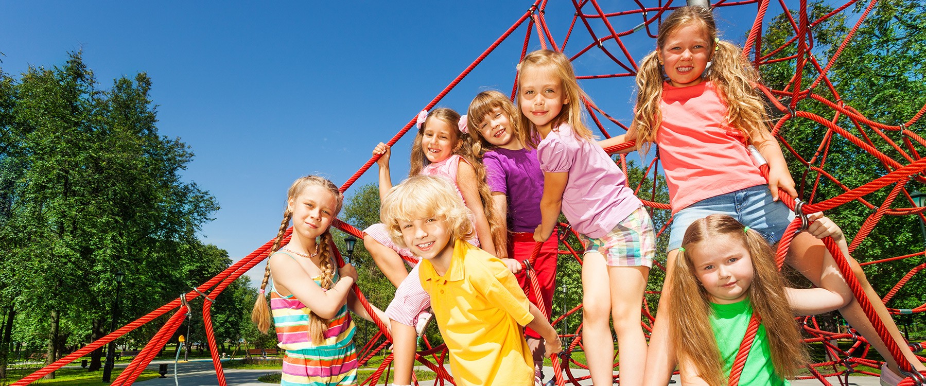 Groupe d'enfants portant des vêtements de couleur vive sont dans un module de toile d'araignée rouge