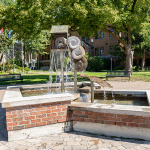 À l'extérieur, au centre d'une place publique, est installée une fontaine d'eau sculptée avec du métal