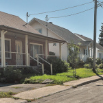 Trois petites maisons avec chacune une cour sont côte à côte sur une rue
