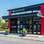 Bâtisse de couleur noir et rouge avec la façade avant fenêtrée