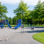 À l'extérieur, module de jeux bleu et mauve avec glissades, stations d'escalade et d'équilibre