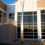 Devant la fenêtre de la bibliothèque, une sculpture en métal forme une longue tige qui s'amincit en hauteur en penchant vers la droite.