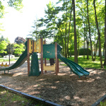 À l'extérieur, module de jeux jaune et vert avec glissades et stations d'escalade